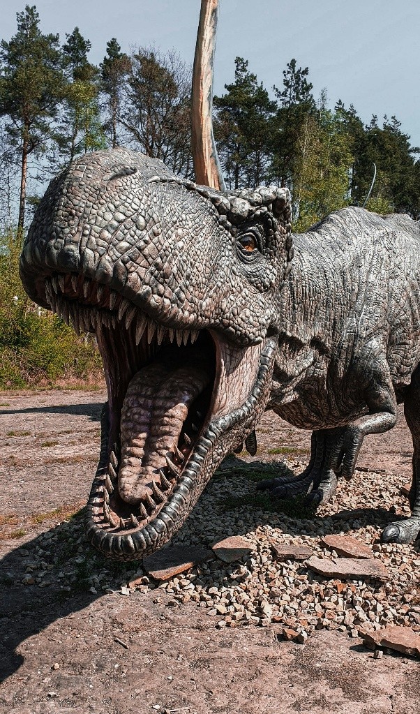 Close up of an animatronic dinosaur with an open mouth .